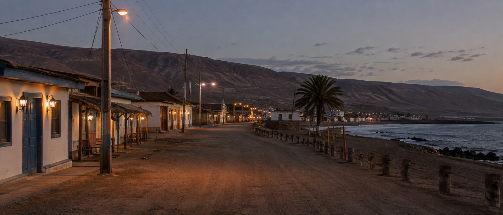 Calle costera de un pueblo del norte al atardecer, con el mar a la derecha.